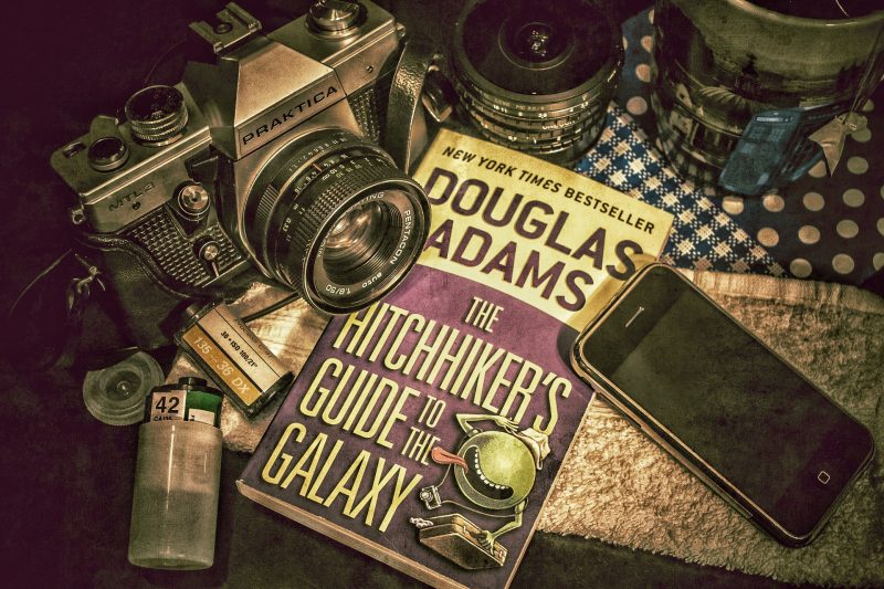 Picture of book, camera, camera rolls, towel